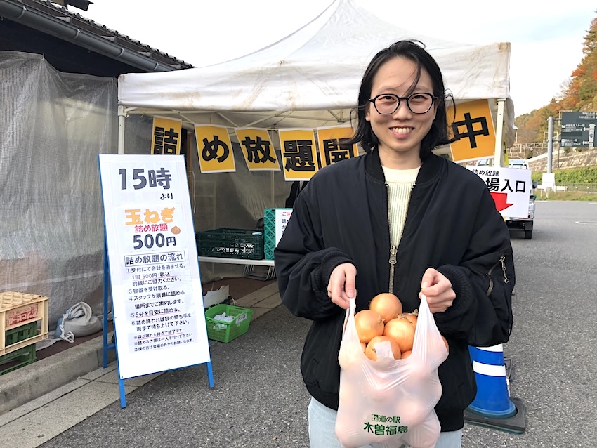 詰め放題の玉ねぎをビニール袋に入れて嬉しがっているみどり